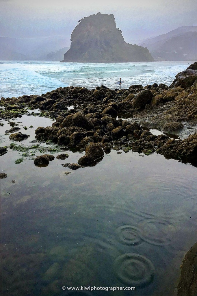 A lone surfer out at Piha in West Auckland