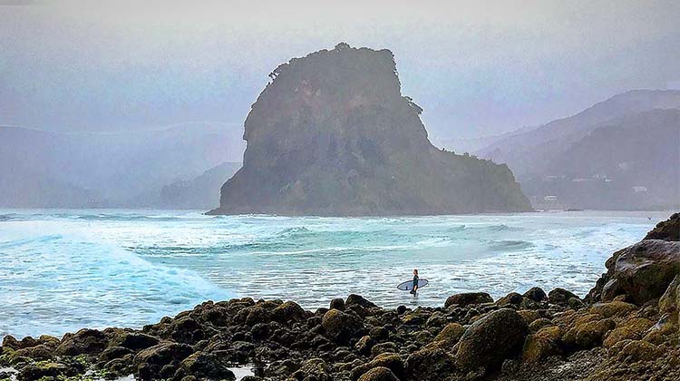 A lone surfer out at Piha, West Auckland.